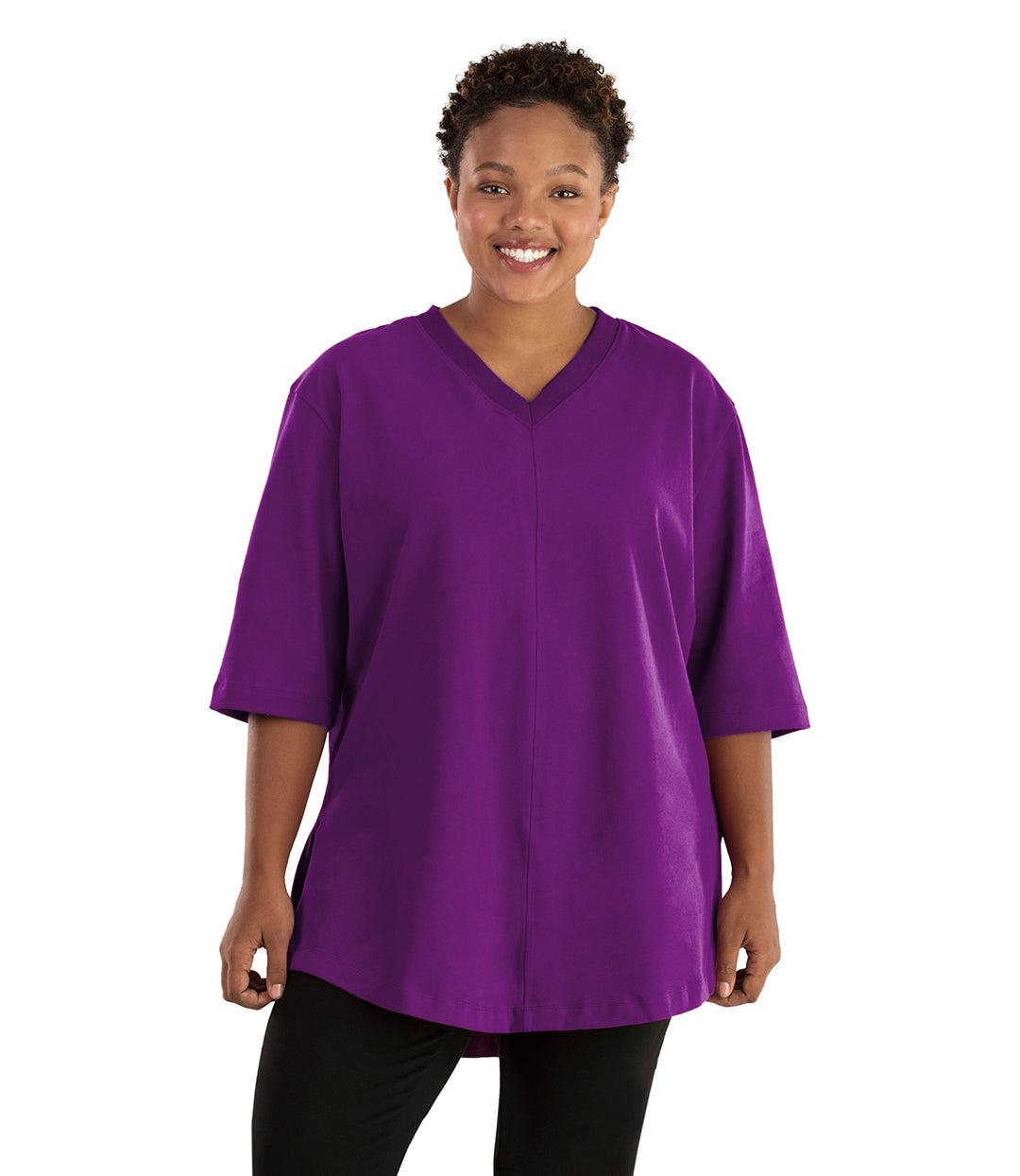 Plus size woman, facing front, wearing JunoActive plus size Legacy Cotton Casual Tunic in the color Heliotrope Purple. She is wearing JunoActive Plus Size Leggings in the color black.