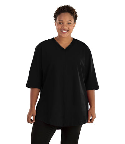 Plus size woman, facing front, wearing JunoActive plus size Legacy Cotton Casual Tunic in the color Black. She is wearing JunoActive Plus Size Leggings in the color black. 
