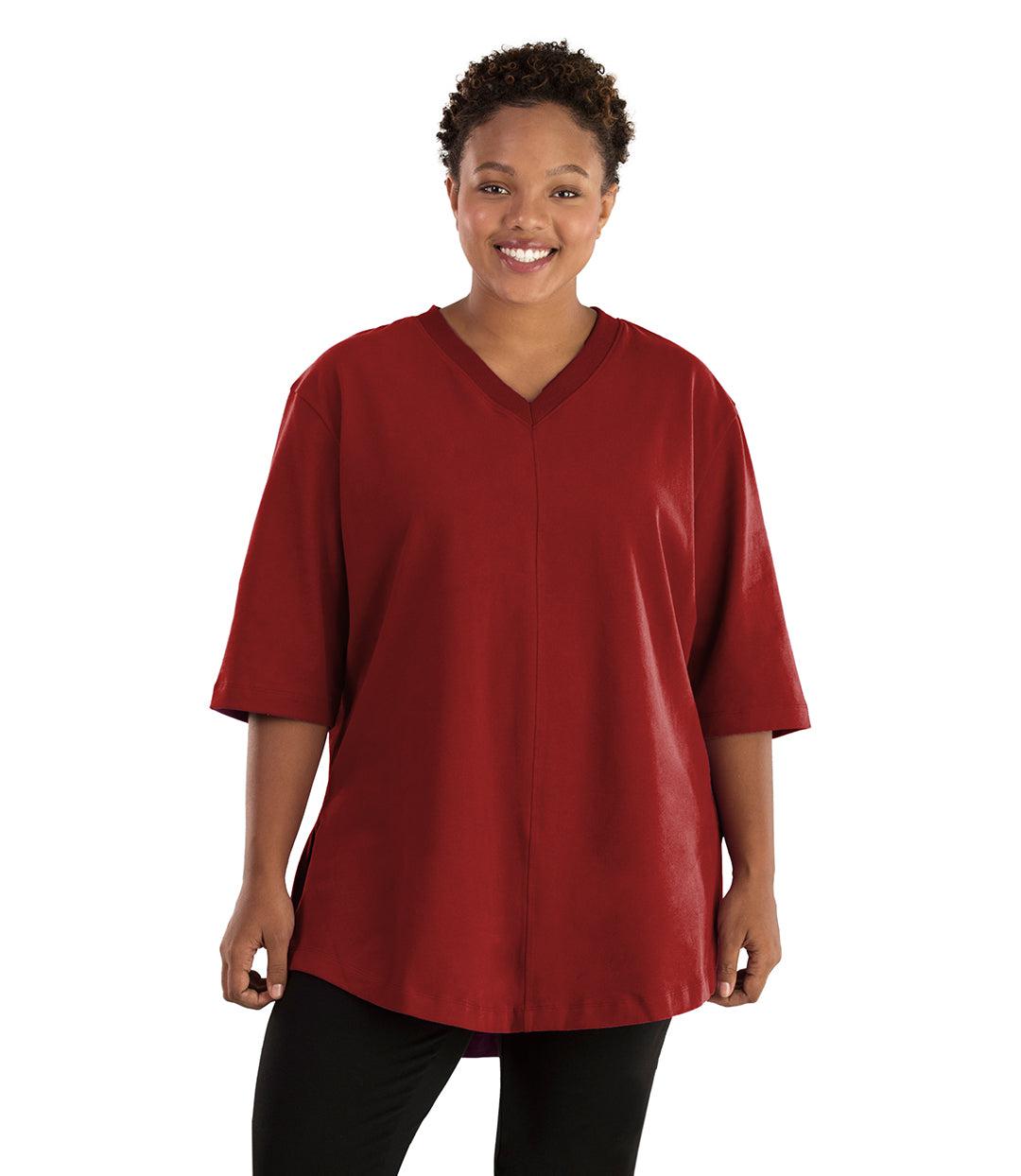 Plus size woman, facing front, wearing JunoActive plus size Legacy Cotton Casual Tunic in the color Merlot Red. She is wearing JunoActive Plus Size Leggings in the color black. 
