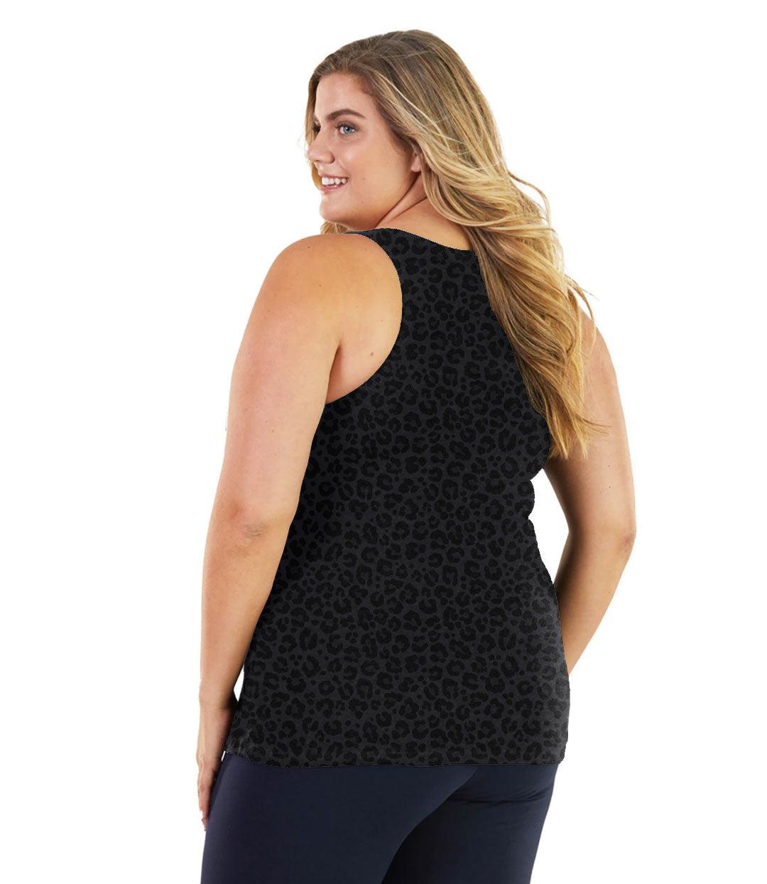 Plus size woman, facing back, wearing JunoActive plus size Stretch Naturals Tank in Deep Leopard Print. The woman is wearing a pair of Navy Blue JunoActive leggings. 