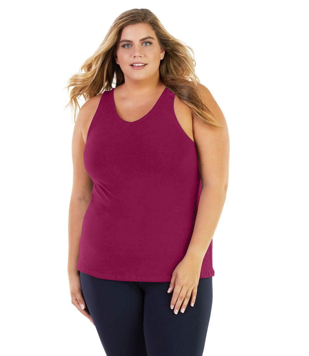 Plus size woman, facing front, wearing JunoActive plus size Stretch Naturals Tank in Merlot. The woman is wearing a pair of Navy Blue JunoActive leggings. 