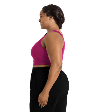 Plus size woman, facing to the side profile, wearing JunoActive plus size Stretch Naturals Scoop Neck Bra in Merlot. The woman is wearing black JunoActive plus size bottoms. Her arms fall naturally to her side.