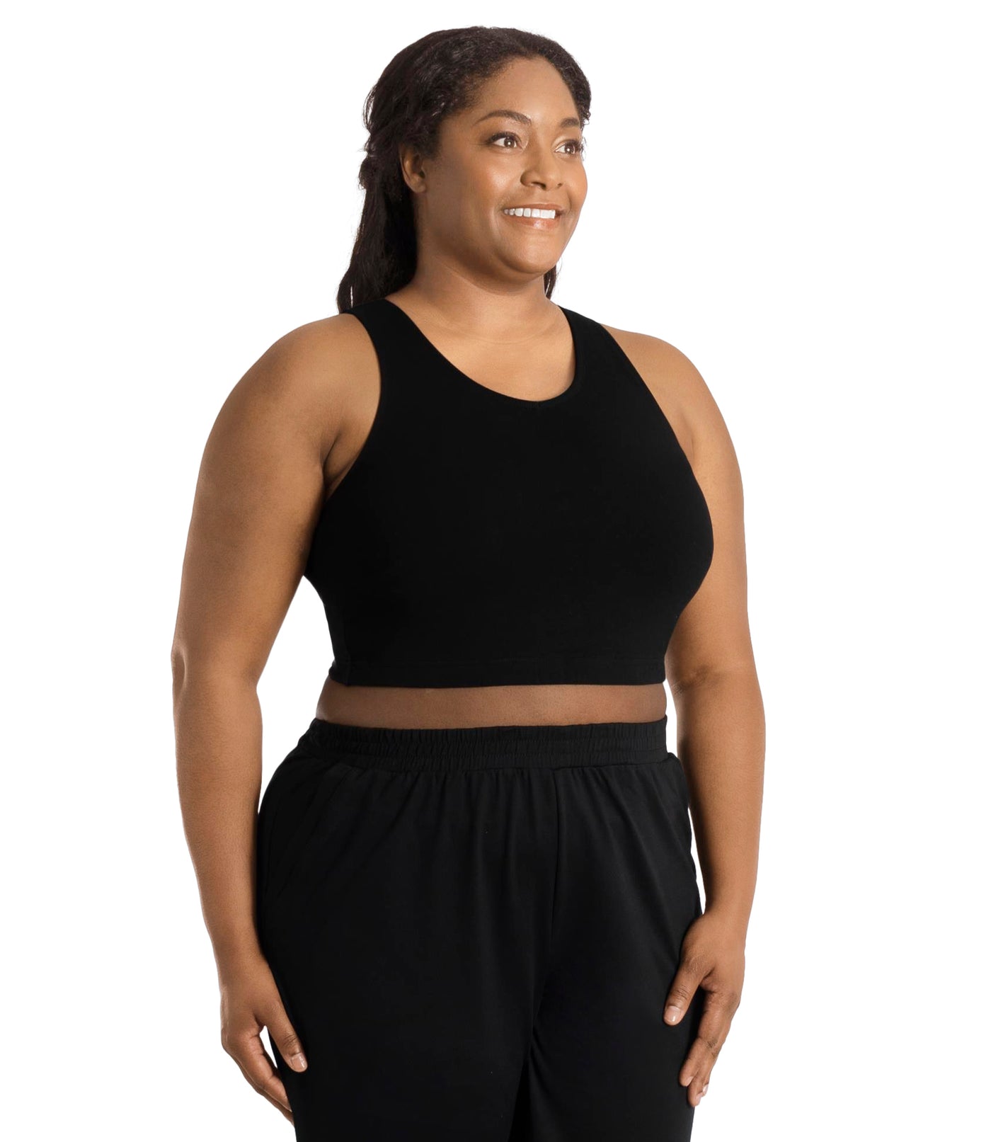 Front view of a plus size woman wearing a black JunoActive Stretch naturals full fit plus size bra.  Featuring  a v-neck and side bust darts for a full fit.  She is also wearing black JunoActive plus size pants.
