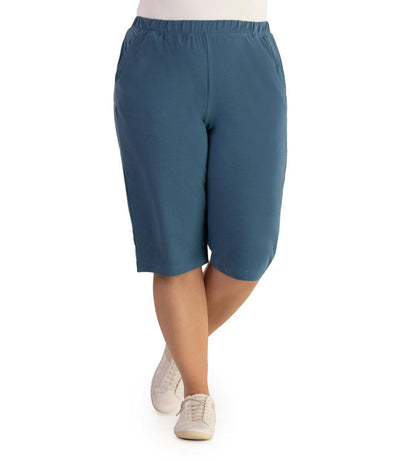 Bottom half of plus sized woman, front view, wearing JunoActive Stretch Naturals Bermuda Shorts in color denim blue. Bottom hem is at the knee.