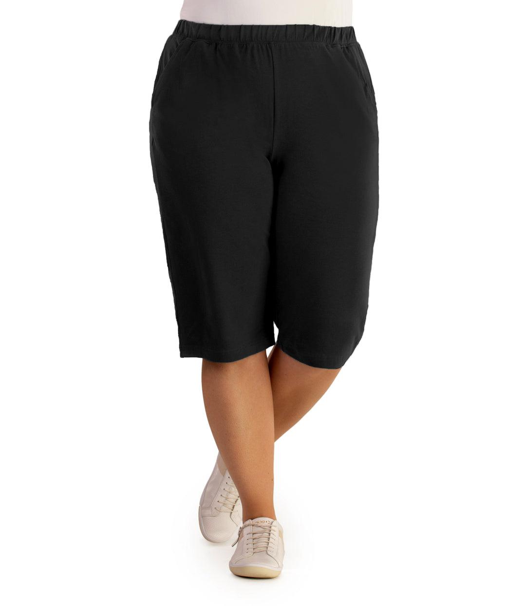 Bottom half of plus sized woman, front view, wearing JunoActive Stretch Naturals Bermuda Shorts in color black. Bottom hem is at the knee.