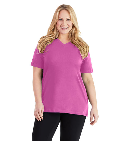 Plus size woman, facing front, wearing JunoActive plus size Stretch Naturals V-Neck in the color Lovely Pink. She is wearing JunoActive Plus Size Leggings in the color black. 