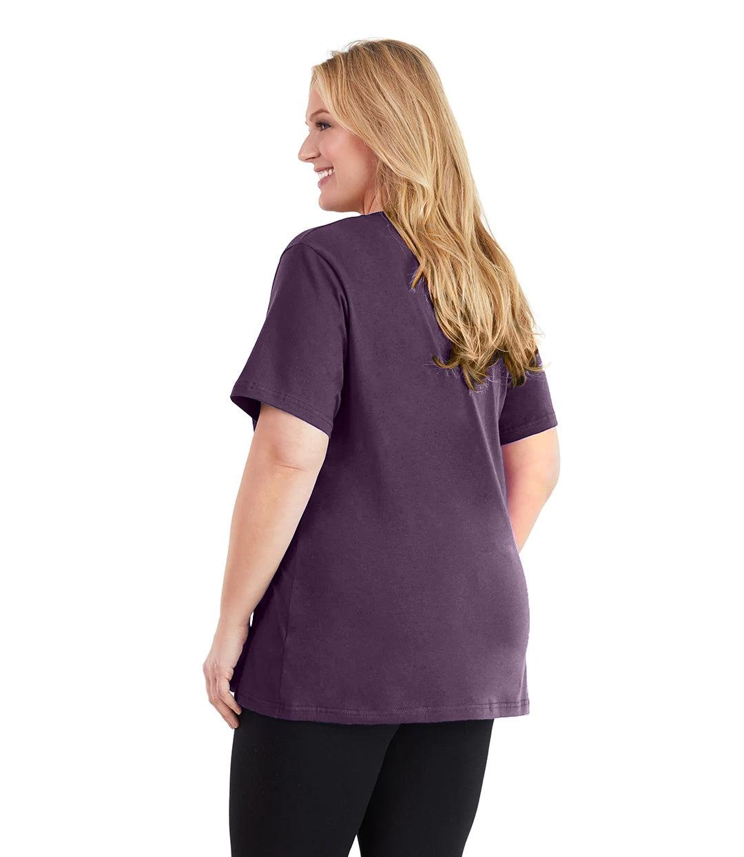 Plus size woman, facing back and looking left, wearing JunoActive plus size Stretch Naturals V-Neck in the color Blackberry. She is wearing JunoActive Plus Size Leggings in the color black.