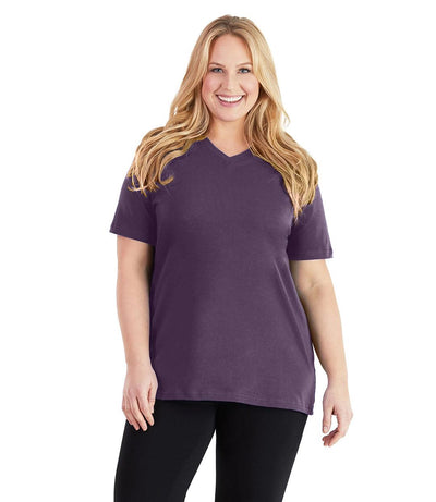 Plus size woman, facing front, wearing JunoActive plus size Stretch Naturals V-Neck in the color Blackberry. She is wearing JunoActive Plus Size Leggings in the color black. 