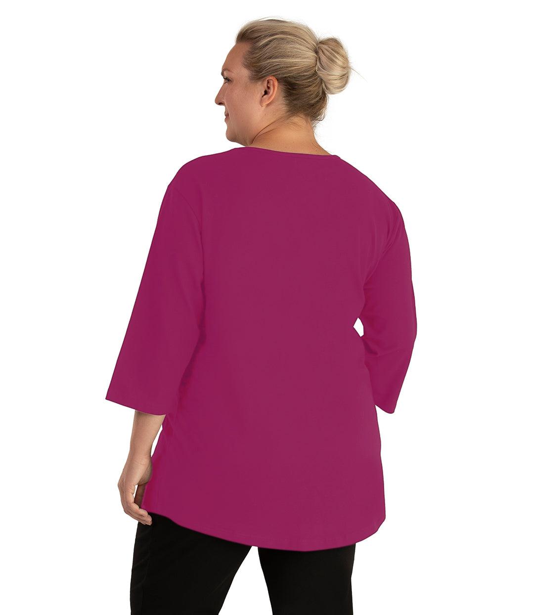 Plus size woman, facing back looking left, wearing JunoActive plus size Stretch Naturals Scoop Neck ¾ Sleeve Top in the color Merlot. She is wearing JunoActive Plus Size Leggings in the color Black.
