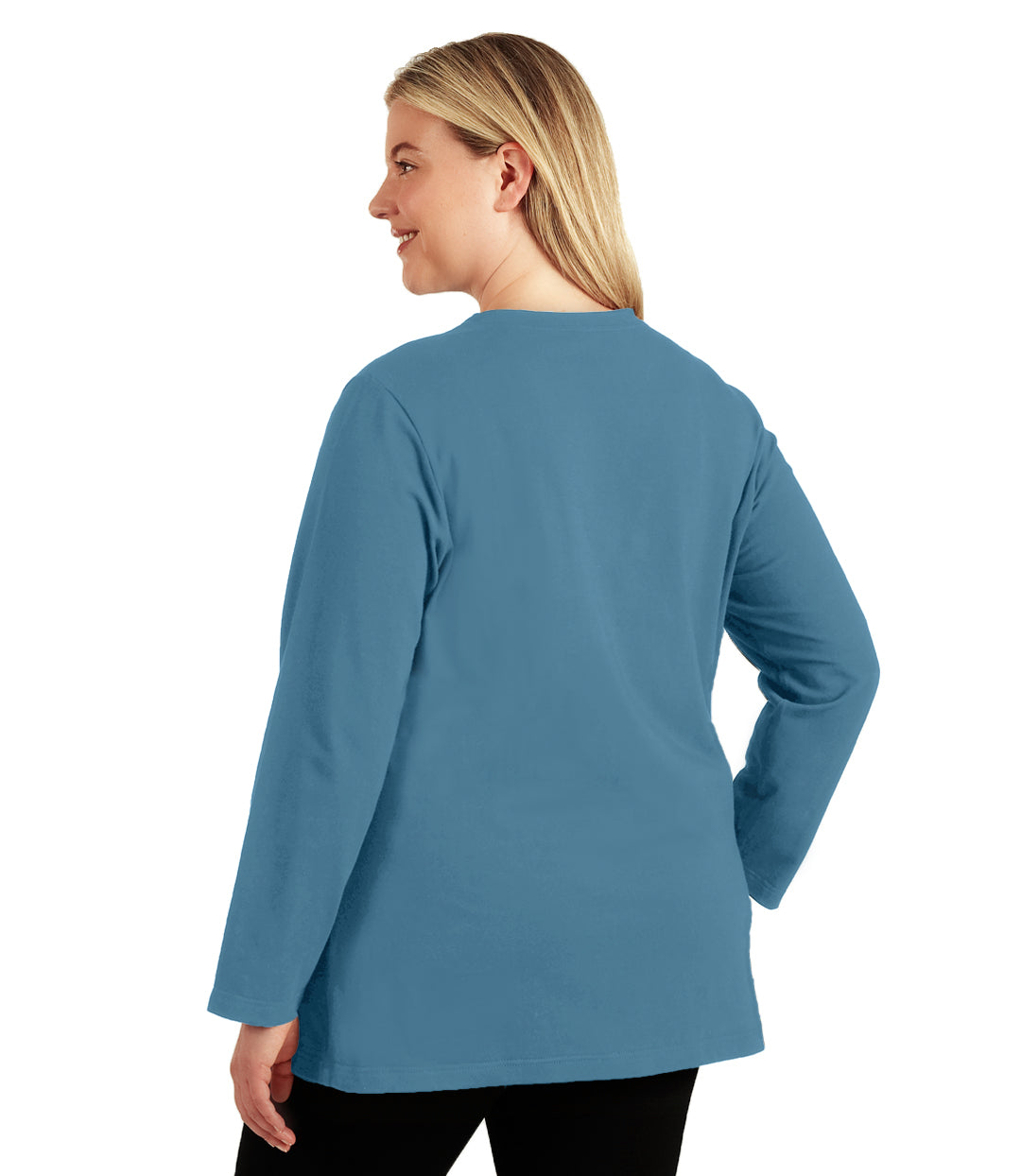 Plus size woman, facing back looking left, wearing JunoActive plus size Stretch Naturals Long Sleeve V-Neck Top in the color Dusty Teal. She is wearing JunoActive Plus Size Leggings in the color Black.