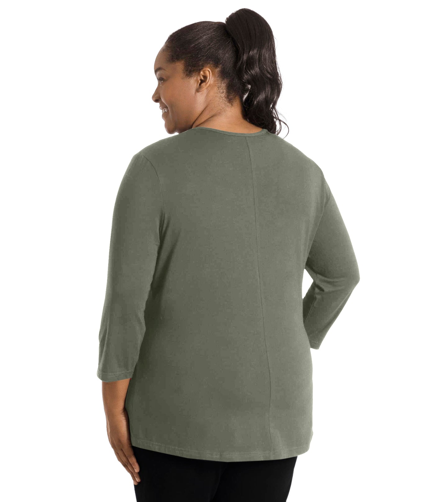 Plus size woman, facing back, wearing JunoActive’s Stretch Naturals Center Seam Scoop Neck 3/4 sleeve top in color moss green. Hands are by side. Pants are in color black. 