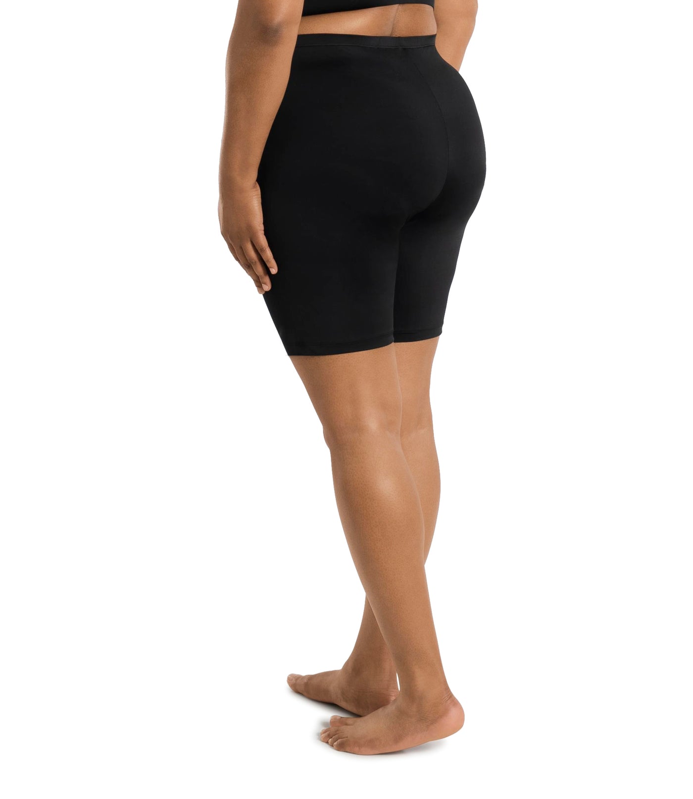 Plus size woman wearing JunoActive's hush full fit boxer in color black. Model is facing back with hands to her side.
