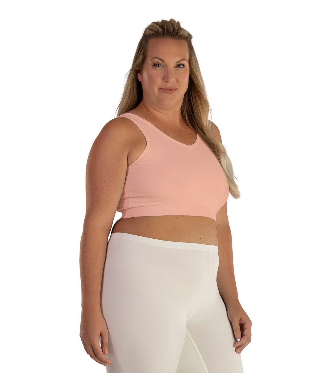 Plus size woman, facing front, wearing JunoActive plus size Junowear Hush V-Neck Bra in Peach. The woman is wearing a white Junowear Hush Boxer brief. Her arms fall naturally to her side.