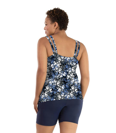 Plus size woman, facing back, wearing JunoActive plus size Junowear Hush Strappy Cami with Bra in Blue Floral Print. The woman is wearing a pair of Navy Blue Junowear Hush Boxer briefs.