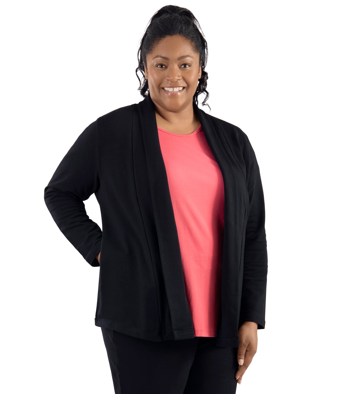 Plus-size model, facing forward, wearing JunoActive's Mavie Cotton Wrap Jacket in color black. Her right hand is in her pocket of jacket and left hand hanging by her side.