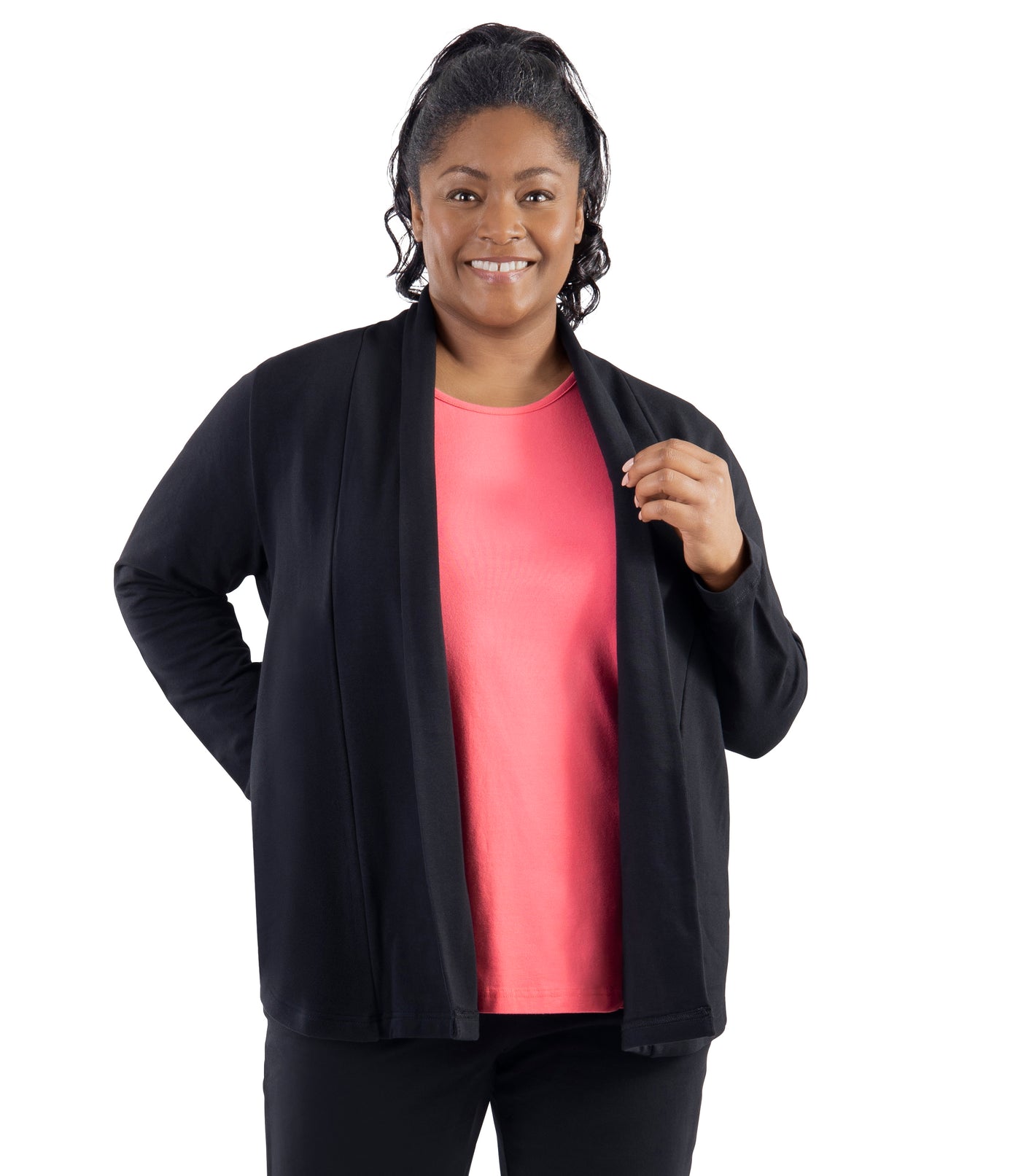 Plus-size model, facing forward, wearing JunoActive's Mavie Cotton Wrap Jacket in color black. Her right hand is in her pocket of jacket and left hand holding top part of jacket.