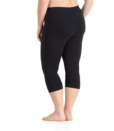 Bottom half of plus sized woman, back view, wearing JunoActive Stretch Naturals Capris in color black. Bottom hem is at mid-calf. 