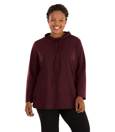 Plus size woman, facing front, wearing JunoActive plus size Stretch Naturals Cowl Top in the color Elderberry. She is wearing JunoActive Plus Size Leggings in the color Black.