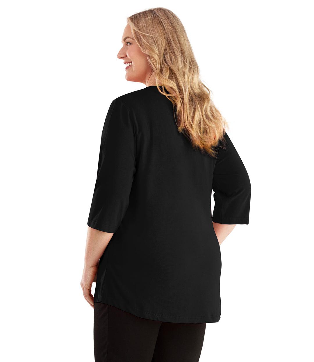 Plus size woman, facing back looking left, wearing JunoActive plus size Stretch Naturals Vee NeckTee in the color Black. She is wearing JunoActive Plus Size Leggings in the color Black. 
