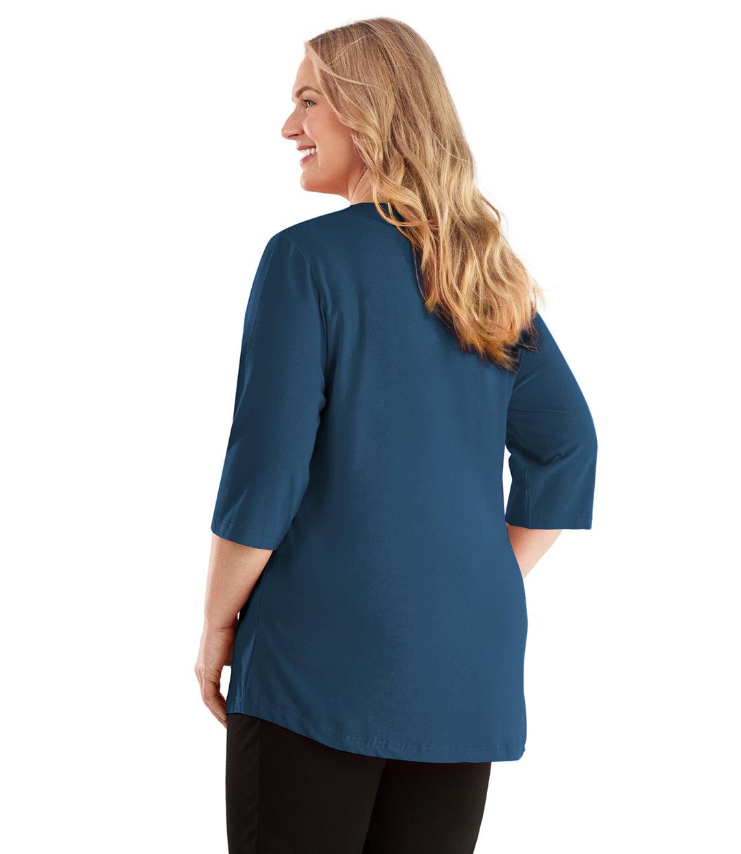 Plus size woman, facing back looking left, wearing JunoActive plus size Stretch Naturals Vee NeckTee in the color French Blue. She is wearing JunoActive Plus Size Leggings in the color Black. 