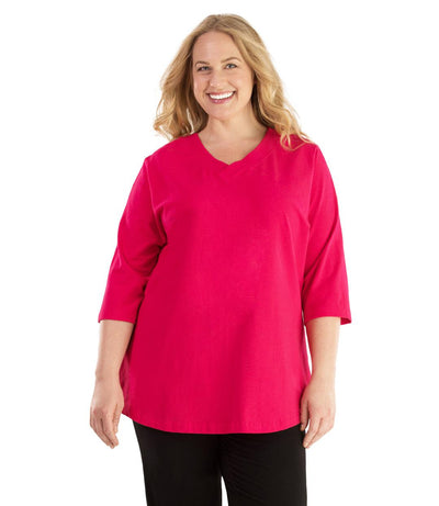 Plus size woman, facing front, wearing JunoActive plus size Stretch Naturals Vee NeckTee in the color Pink. She is wearing JunoActive Plus Size Leggings in the color Black. 