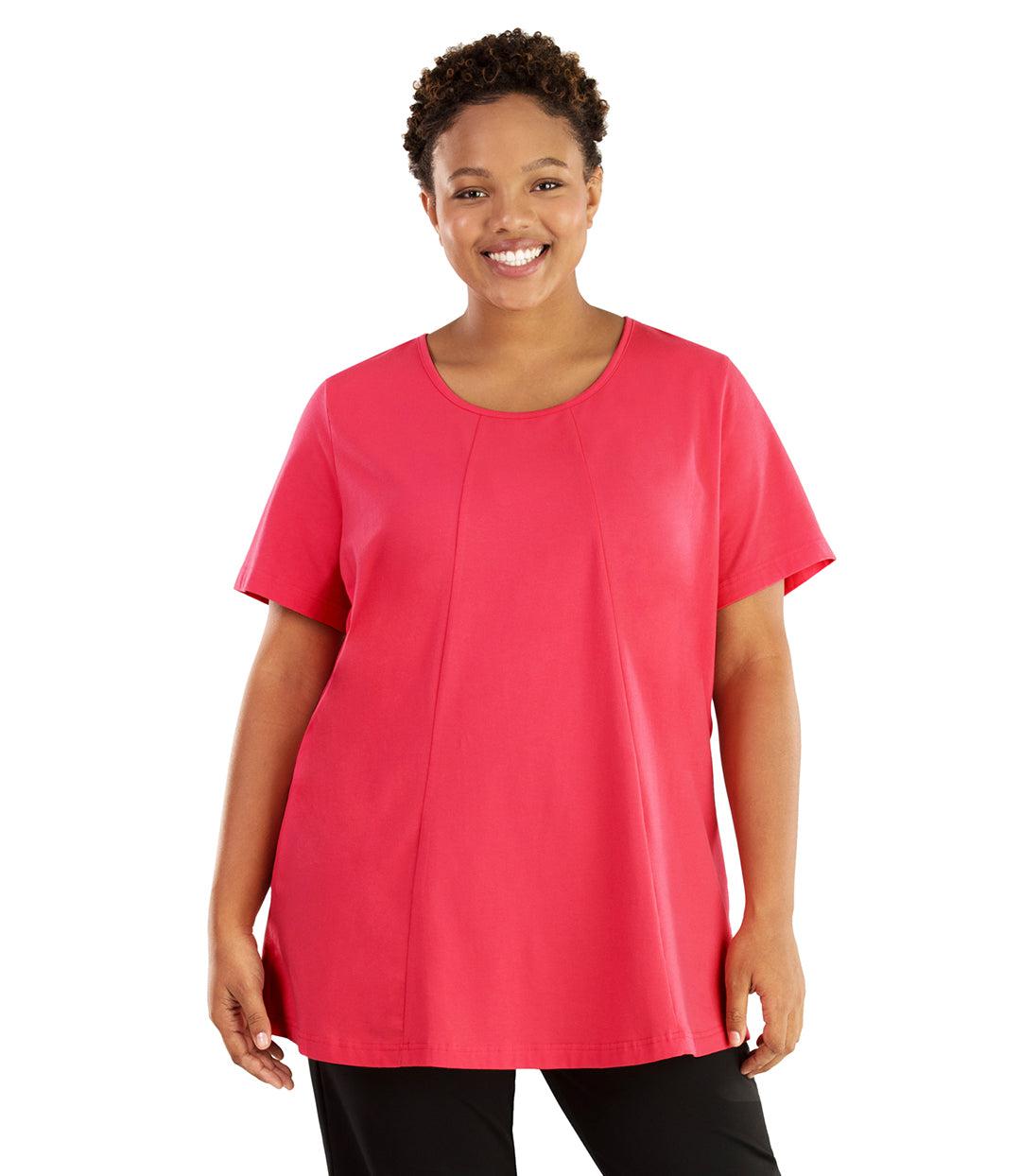 Plus size woman, facing front, wearing JunoActive plus size Stretch Naturals Lite Swing Top in the color Pink. She is wearing JunoActive Plus Size Leggings in the color black. 