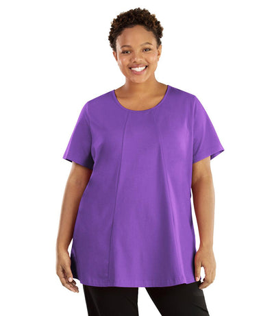 Plus size woman, facing front, wearing JunoActive plus size Stretch Naturals Lite Swing Top in the color Purple. She is wearing JunoActive Plus Size Leggings in the color black. 