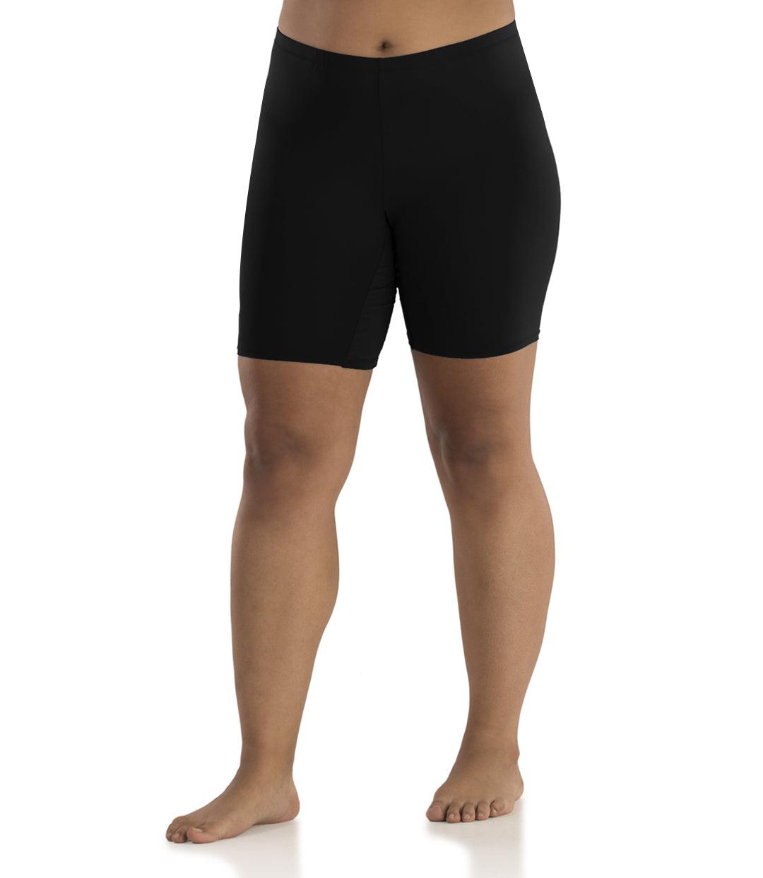 Bottom half of plus sized woman, facing front, wearing JunoActive Junowear Hush Boxer Brief in black. This fitted boxer fits to the waistline and leg opening is a few inches above the knee.