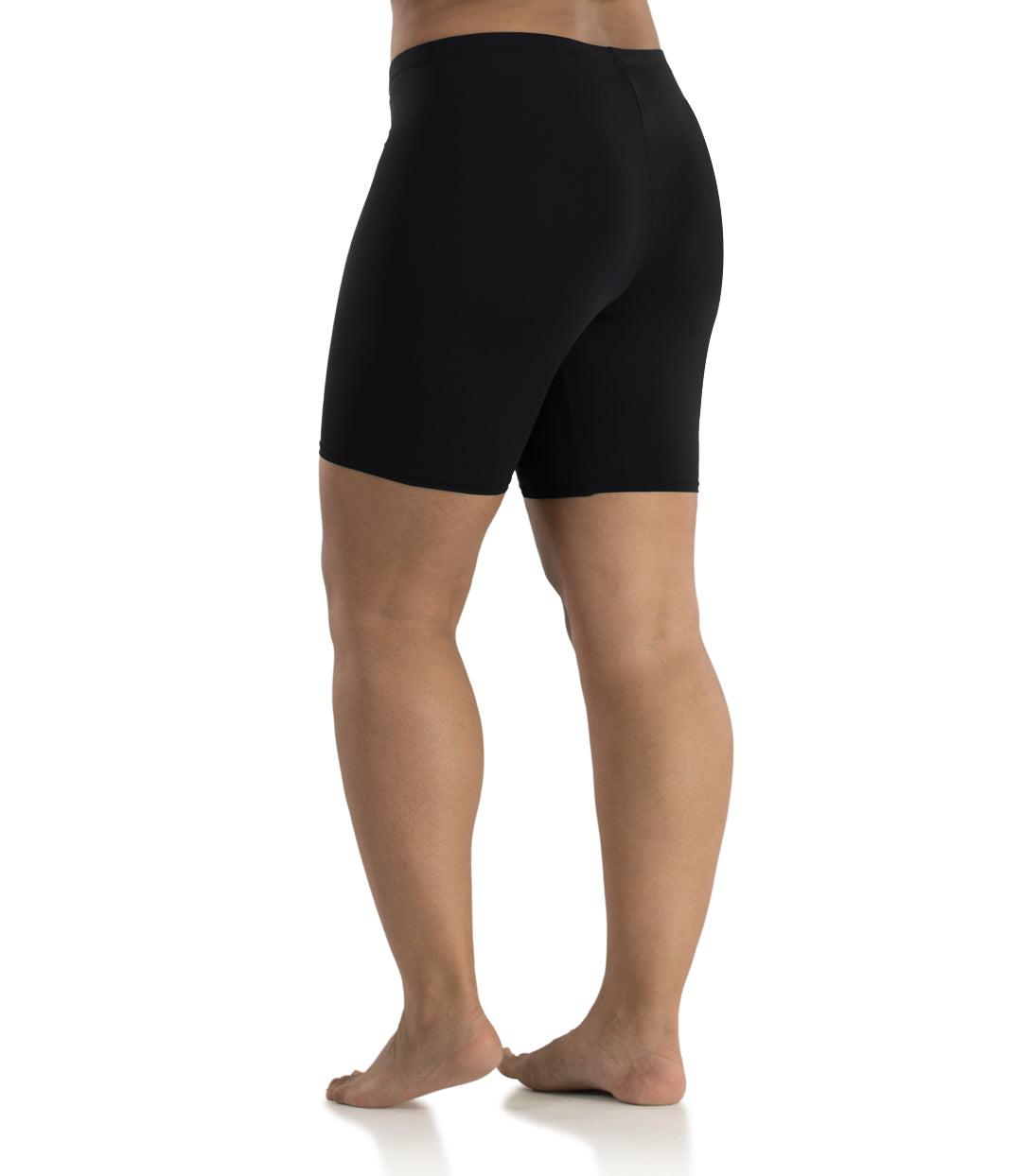 Bottom half of plus sized woman, back view, wearing JunoActive Junowear Hush Boxer Brief in black. This fitted boxer fits to the waistline and leg opening is a few inches above the knee.