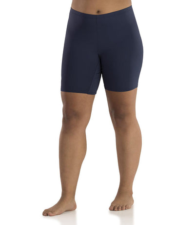 Bottom half of plus sized woman, facing front, wearing JunoActive Junowear Hush Boxer Brief in navy. This fitted boxer fits to the waistline and leg opening is a few inches above the knee.