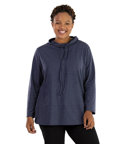 Plus size woman, facing front, wearing JunoActive plus size Stretch Naturals Cowl Top in the color Denim Blue. She is wearing JunoActive Plus Size Leggings in the color Black.