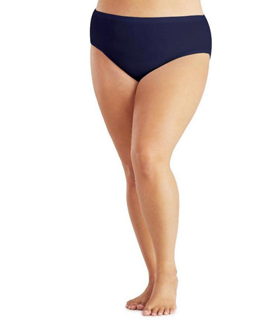 Bottom half of plus sized woman, facing front, wearing JunoActive Junowear Hush Midrise Brief in navy. This brief fits a couple inches below the waistline with a conservative leg opening.